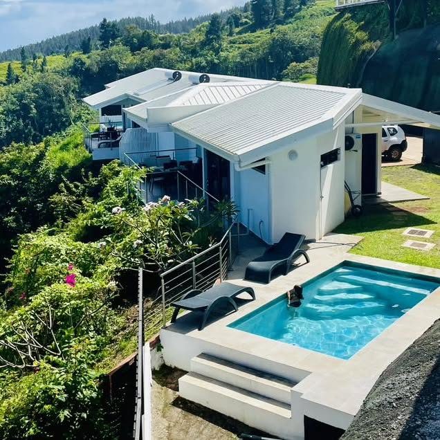 Villa Iti, maison blanche et sa piscine dans la verdure
